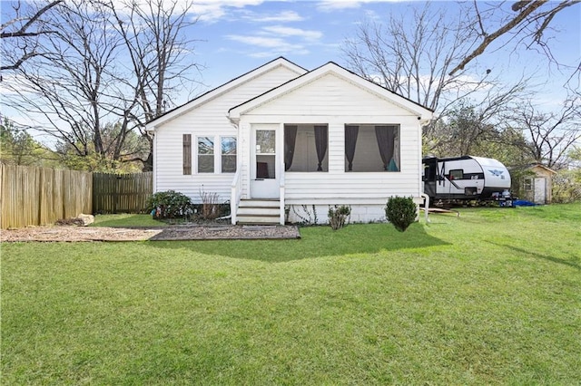 bungalow with entry steps, a front yard, and fence