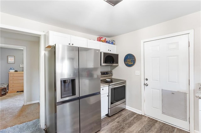 kitchen featuring dark wood-type flooring, white cabinets, baseboards, and stainless steel appliances