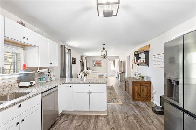 kitchen featuring plenty of natural light, dishwasher, a ceiling fan, and a peninsula