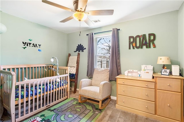 bedroom featuring a crib, baseboards, visible vents, and light carpet