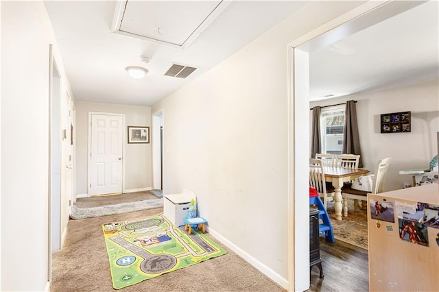 hall featuring visible vents, carpet flooring, attic access, and baseboards