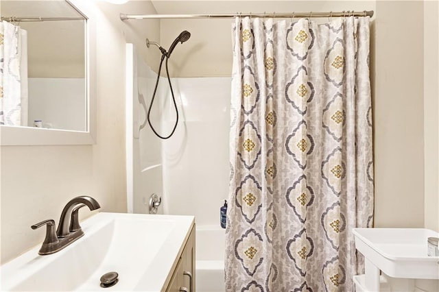 bathroom with shower / bath combo with shower curtain and a sink