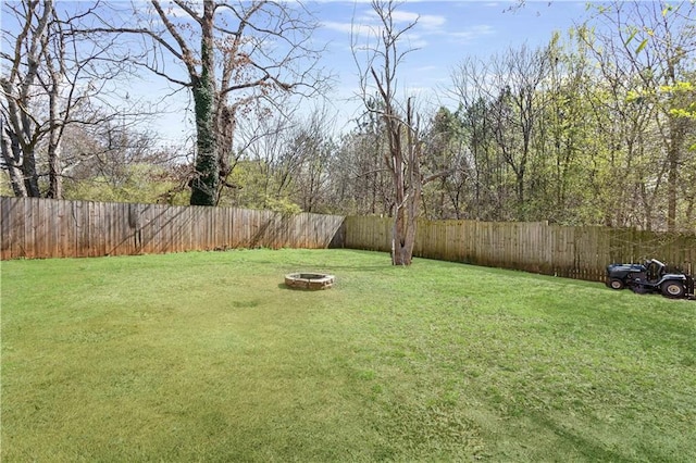 view of yard featuring an outdoor fire pit and a fenced backyard