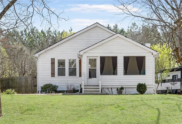 bungalow-style house featuring a front lawn and fence