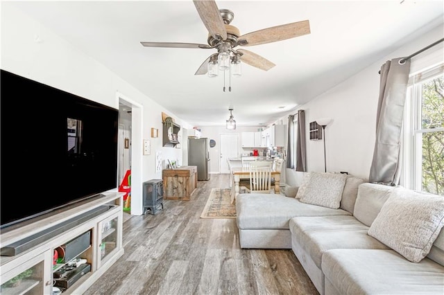 living area featuring light wood-style floors and a ceiling fan