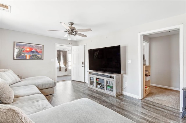 living area with visible vents, baseboards, ceiling fan, and wood finished floors