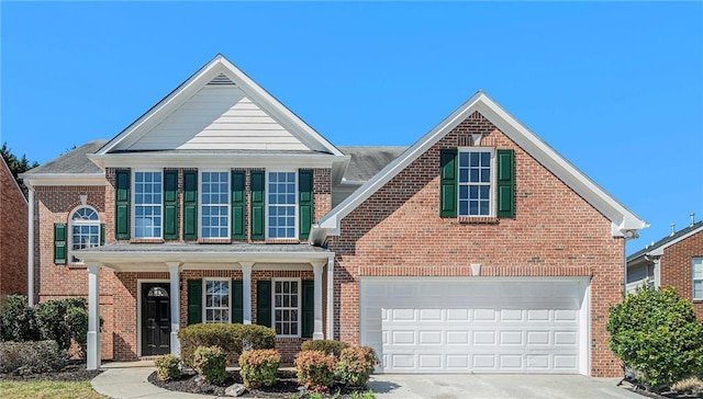 traditional-style home with a garage, brick siding, a porch, and concrete driveway