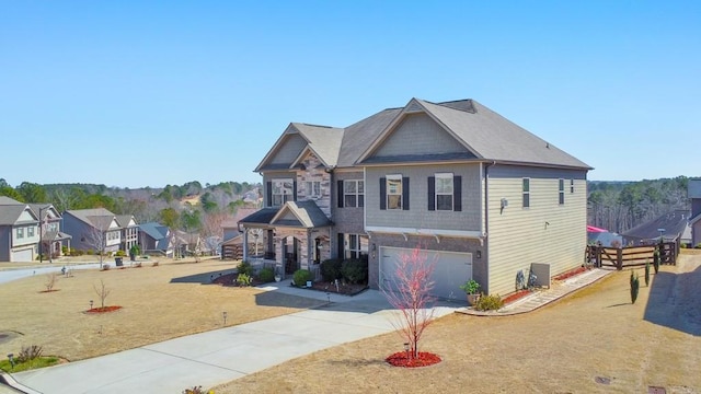 craftsman inspired home with a garage, stone siding, a front lawn, and driveway