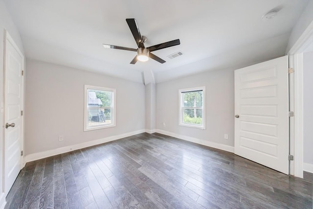 spare room with ceiling fan, a healthy amount of sunlight, and dark hardwood / wood-style floors