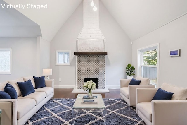 living room with a fireplace, dark hardwood / wood-style flooring, and high vaulted ceiling