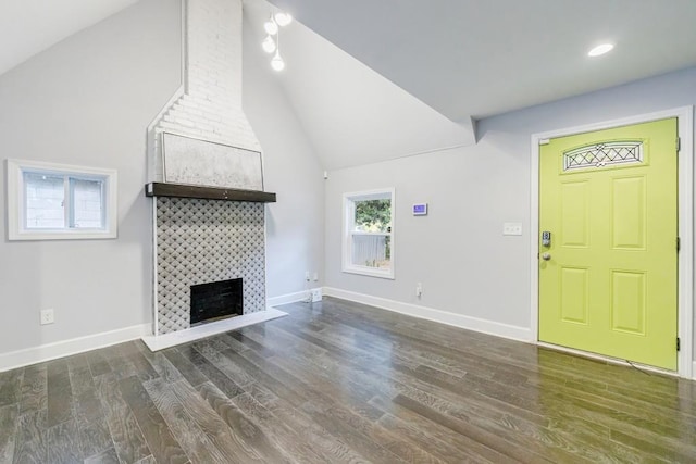 unfurnished living room with dark hardwood / wood-style flooring, a fireplace, and vaulted ceiling