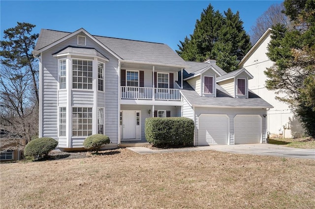 view of front of property with a garage, a front yard, driveway, and a balcony