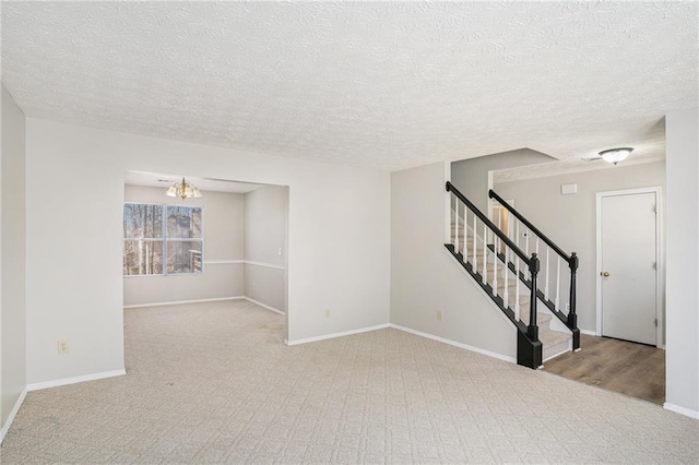 empty room featuring stairway, carpet flooring, and baseboards