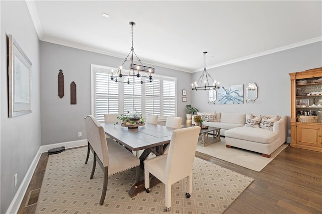 dining room with a chandelier, ornamental molding, and light hardwood / wood-style flooring