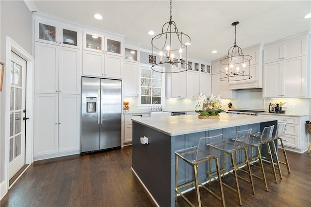 kitchen with dark hardwood / wood-style flooring, white cabinetry, high quality fridge, and pendant lighting