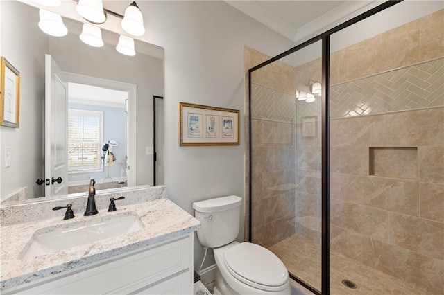 bathroom with toilet, ornamental molding, vanity, and a shower with door