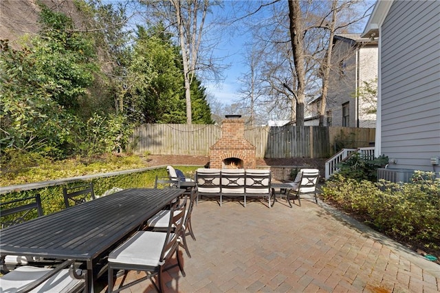 view of terrace with central AC unit and an outdoor brick fireplace