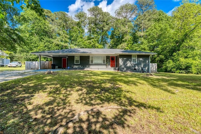 ranch-style home with fence, an attached carport, a front yard, concrete driveway, and covered porch