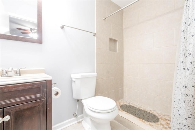 bathroom with vanity, a tile shower, and toilet