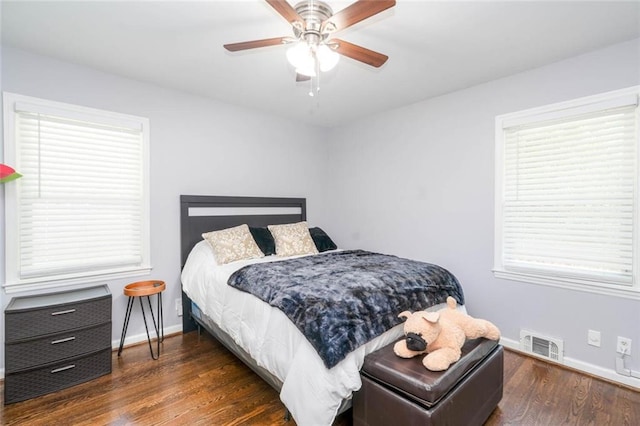 bedroom featuring baseboards, ceiling fan, wood finished floors, and visible vents