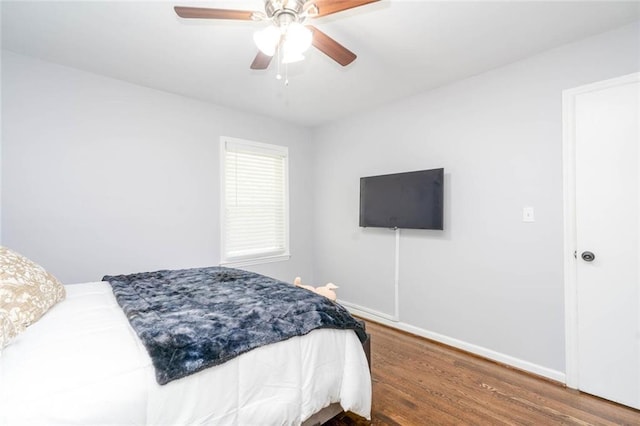 bedroom featuring baseboards, a ceiling fan, and wood finished floors