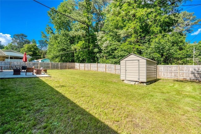 view of yard featuring a storage unit, a fenced backyard, a patio area, and an outdoor structure