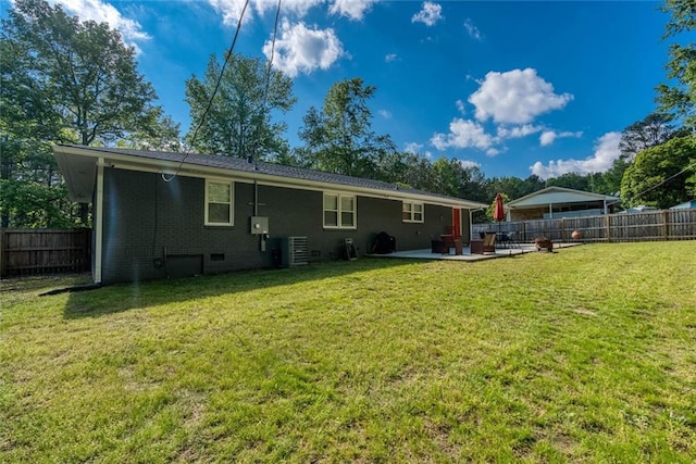 rear view of property featuring a patio, a fenced backyard, and a lawn