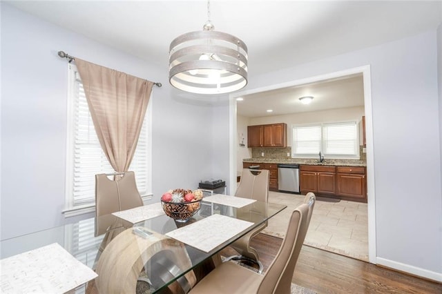 dining area with an inviting chandelier, baseboards, and wood finished floors