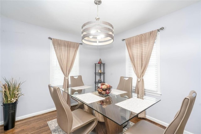 dining area featuring baseboards, wood finished floors, and a chandelier
