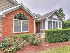 rear view of property featuring brick siding and a sunroom