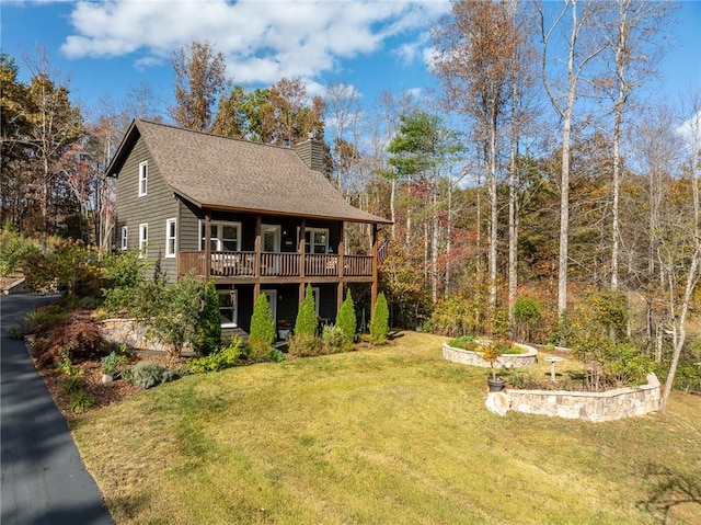 back of property featuring a deck and a lawn