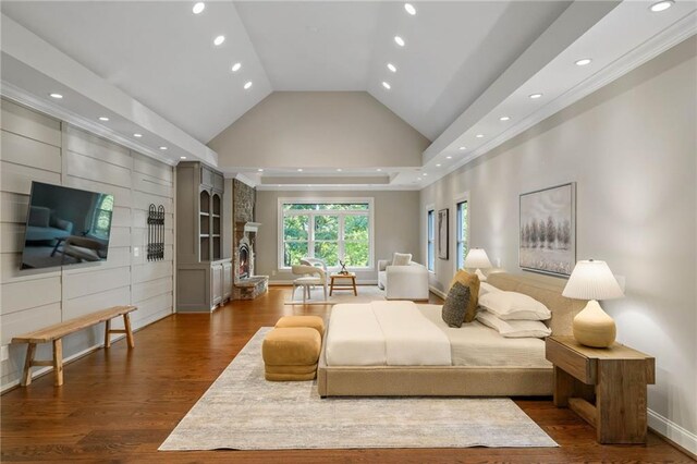 bedroom featuring dark hardwood / wood-style flooring, high vaulted ceiling, and a raised ceiling