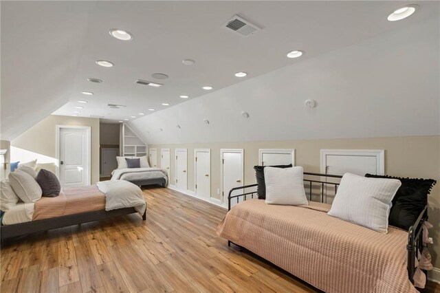 bedroom featuring light hardwood / wood-style flooring and lofted ceiling