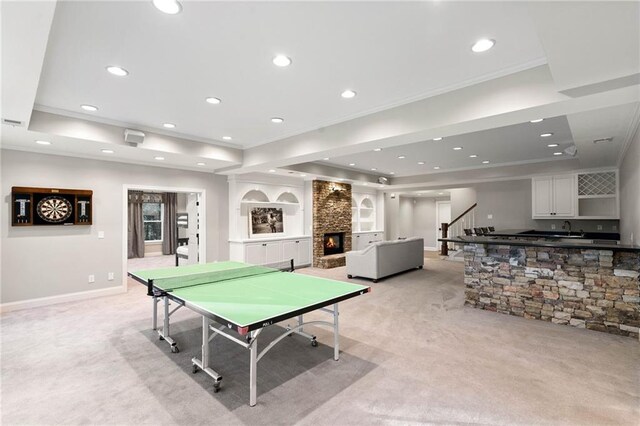 game room featuring a raised ceiling, sink, light carpet, and a fireplace