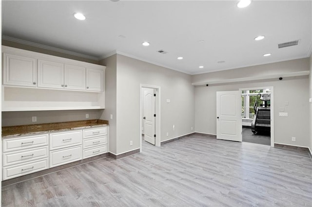 interior space with light hardwood / wood-style flooring and crown molding