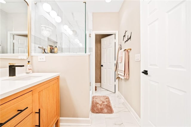 full bath featuring marble finish flooring, a walk in shower, baseboards, and vanity