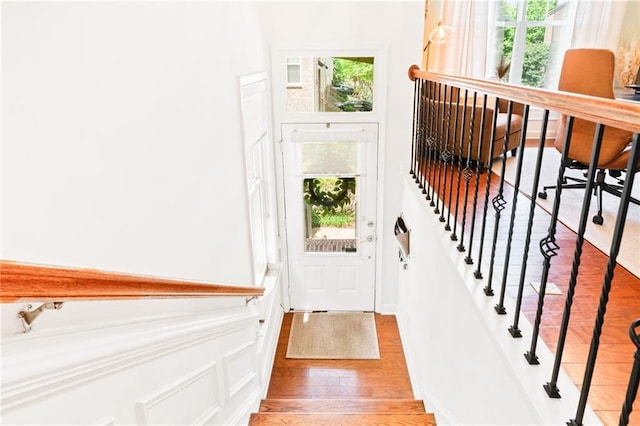 doorway with light wood-style floors and a decorative wall
