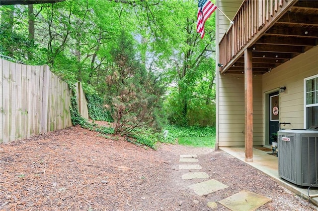 view of yard with central AC unit and fence