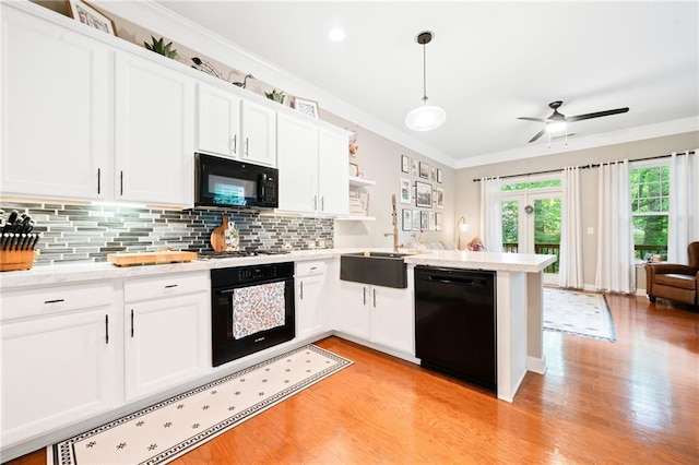 1996 Cobblestone Cir NE, Atlanta, GA 30319 - kitchen featuring black appliances, light wood-style flooring, crown molding, backsplash, and a peninsula