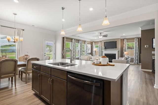 kitchen featuring a fireplace, open floor plan, a sink, ceiling fan with notable chandelier, and dishwasher