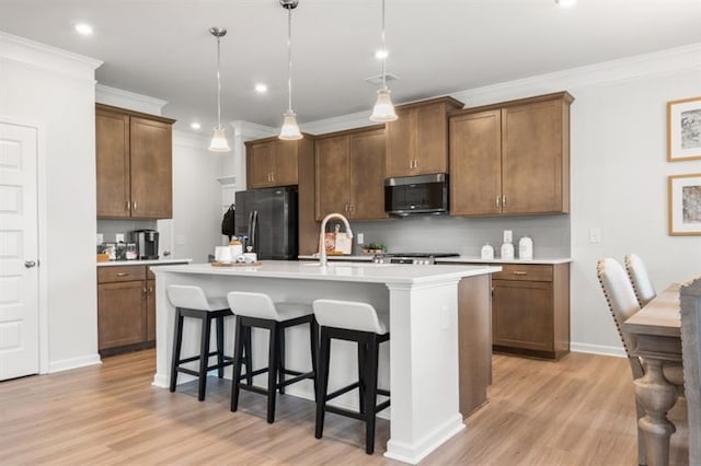 kitchen with stainless steel microwave, tasteful backsplash, light wood-style floors, and black fridge with ice dispenser