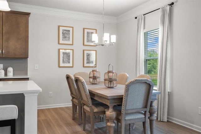 dining area with crown molding, baseboards, an inviting chandelier, and wood finished floors