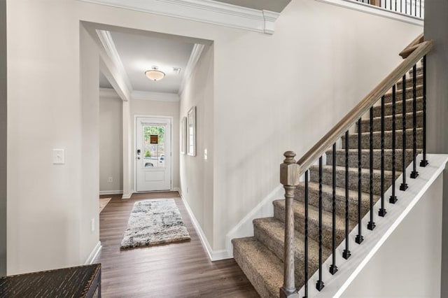foyer featuring crown molding, stairs, baseboards, and wood finished floors