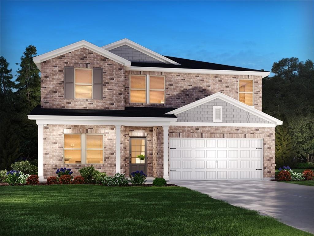 traditional-style house with a garage, a front lawn, brick siding, and driveway