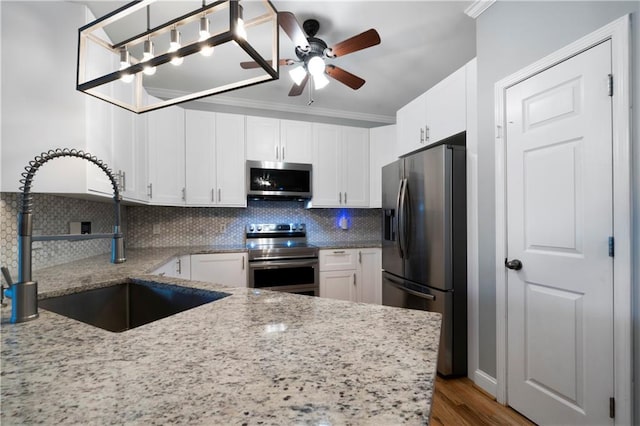 kitchen with backsplash, white cabinets, sink, and appliances with stainless steel finishes