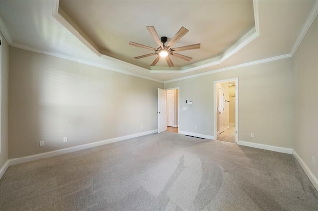 spare room featuring ceiling fan, ornamental molding, light carpet, and a tray ceiling