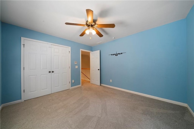 unfurnished bedroom with ceiling fan, a closet, and light colored carpet