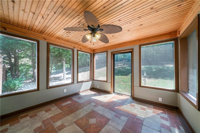 unfurnished sunroom with ceiling fan, a healthy amount of sunlight, and wood ceiling