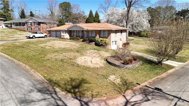 single story home with a front lawn, a garage, and driveway