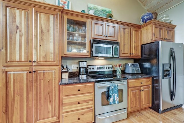 43 Morley Dr, Ellijay, GA 30540 - kitchen with appliances with stainless steel finishes, light wood-type flooring, vaulted ceiling, glass insert cabinets, and dark stone countertops